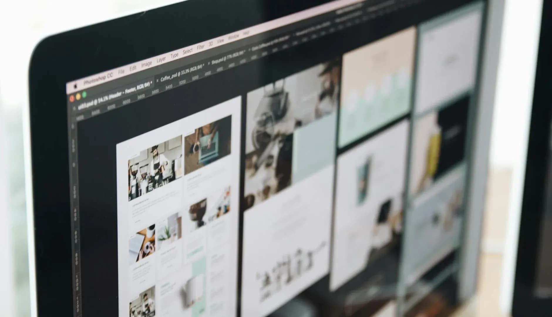 A modern computer screen in a workspace displaying creative web design visuals for small business websites.